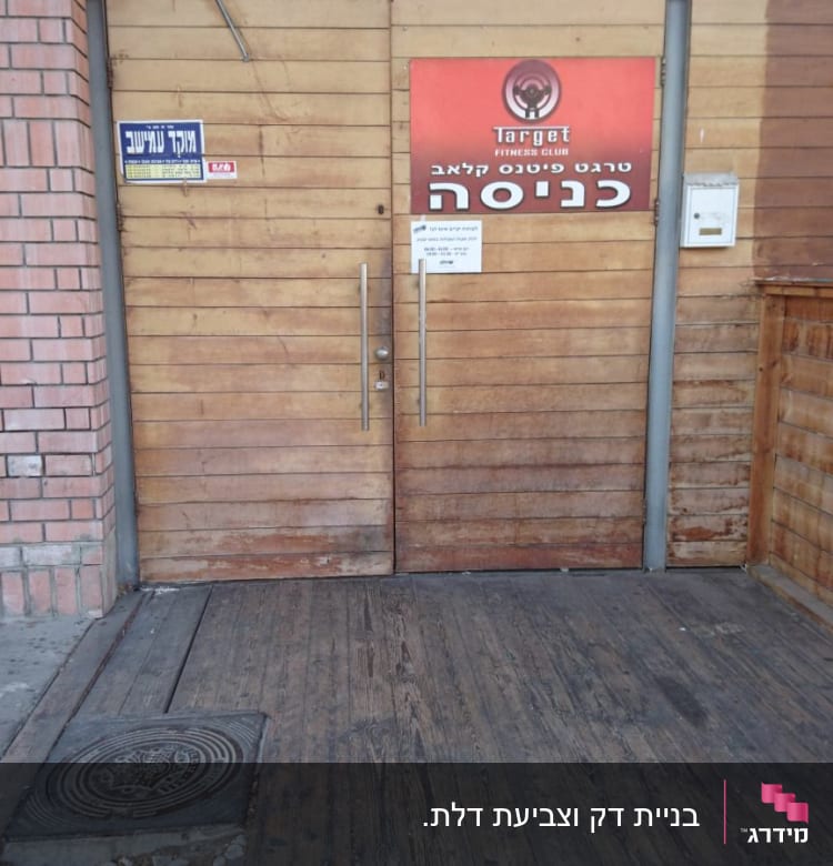 דלת עץ עם שלט כניסה למועדון כושר